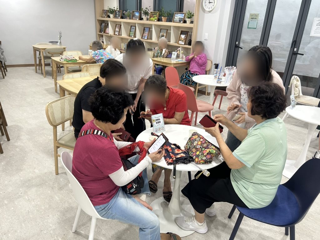 성북 함께어울림센터에서 학생들이 어르신들에게 스마트폰 사용법을 알려드리는 모습